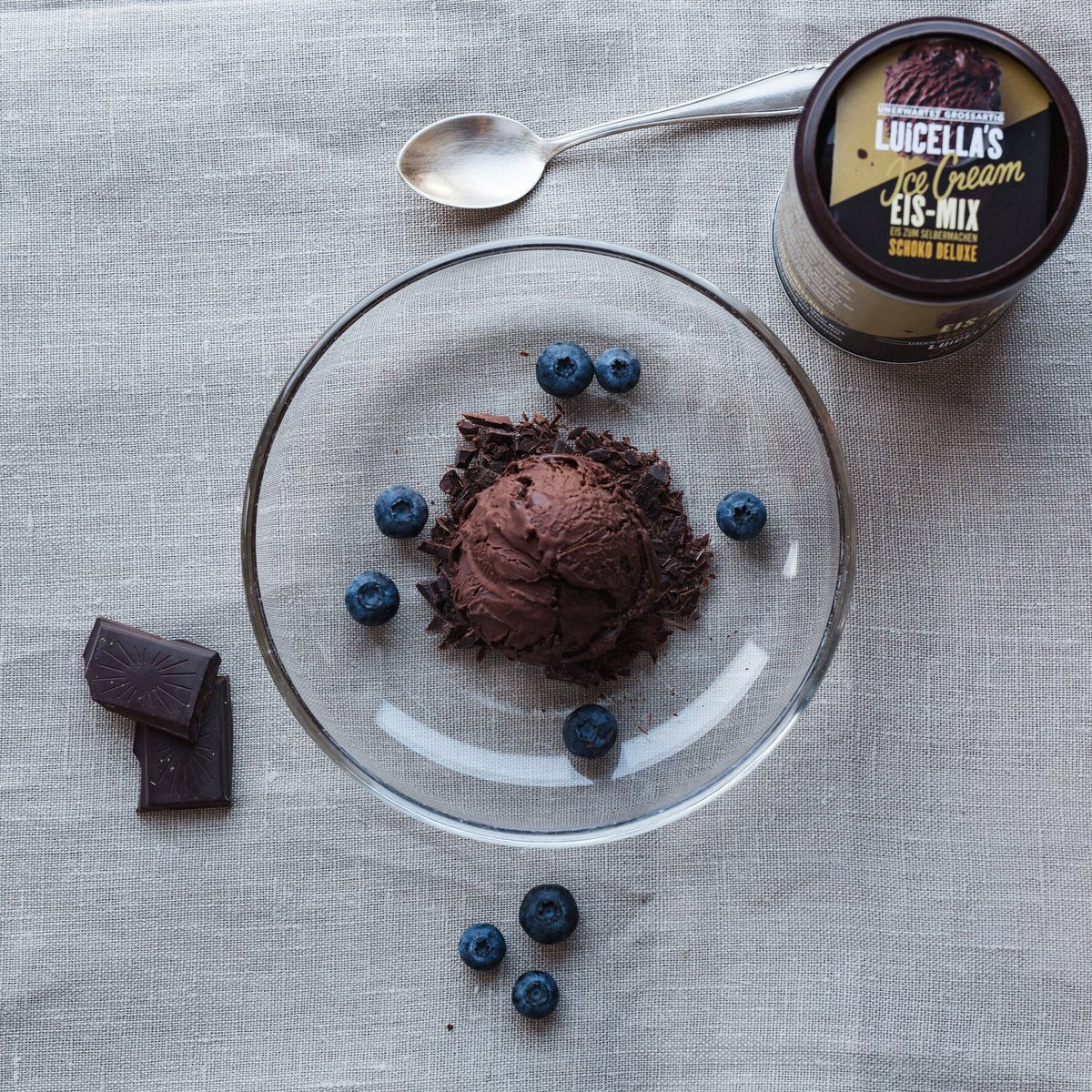 Serviervorschlag von fertigem Eis in Schale mit Schokoraspeln und Johannisbeeren
