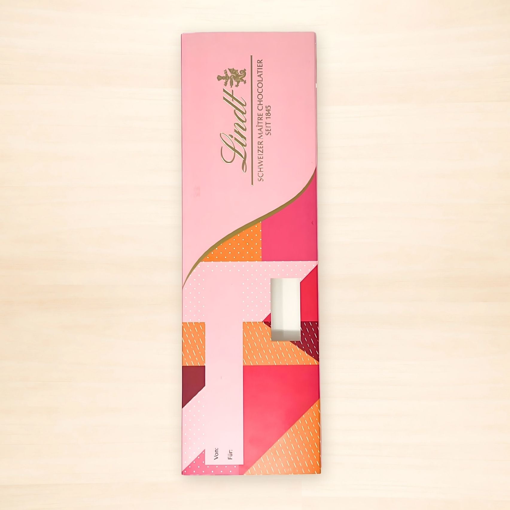 Rückseite der Lindt „LOVE you“ Geschenkverpackung mit rosa Musterdesign, Einsteckfach für eine Schokoladentafel sowie beschriftbaren Feldern „von“ und „für“ zur persönlichen Widmung