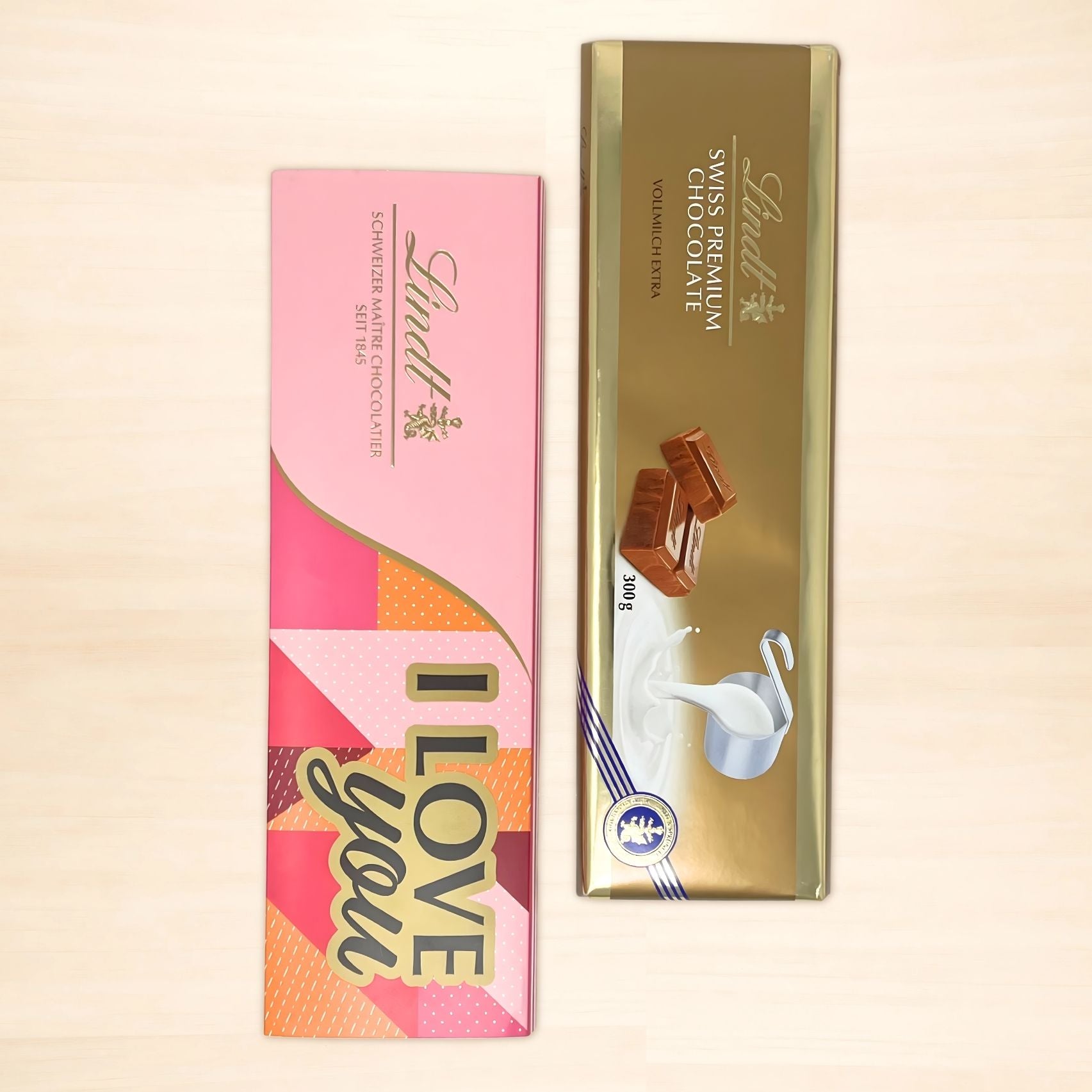 Lindt Alpenvollmilch Extra Tafel, 300g in goldener Verpackung und passender Tafelschuber in Pink mit der Aufschrift "I love you"