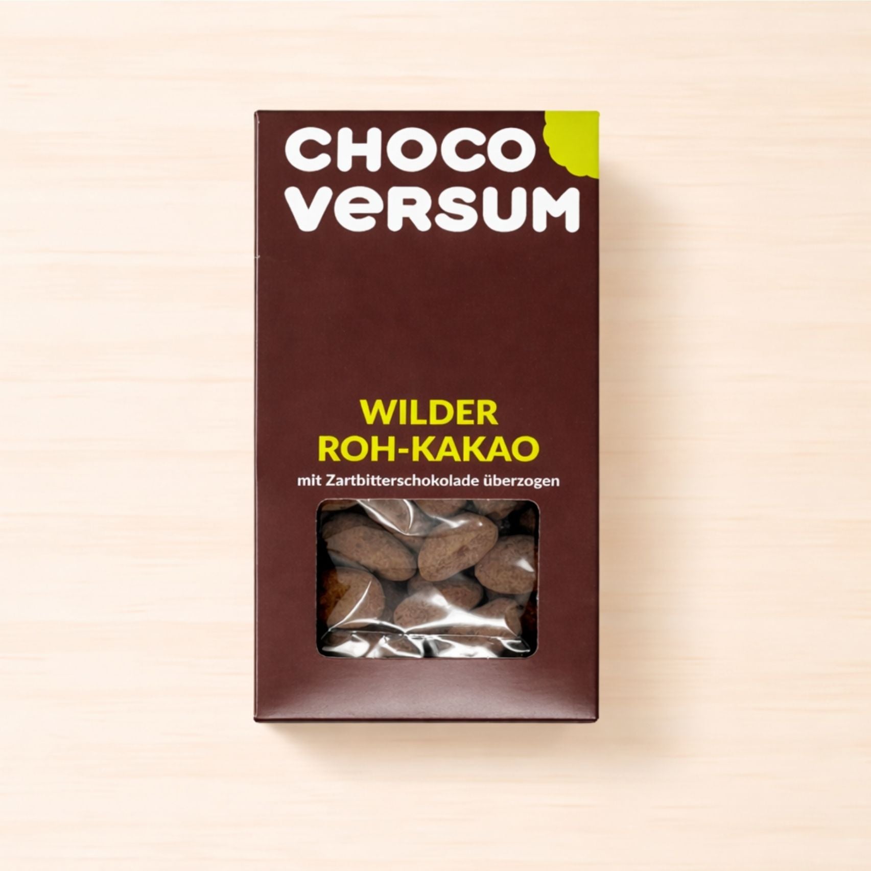Verpackung mit wilden Kakaobohnen, überzogen mit Zartbitterschokolade, in brauner CHOCOVERSUM-Box mit Sichtfenster