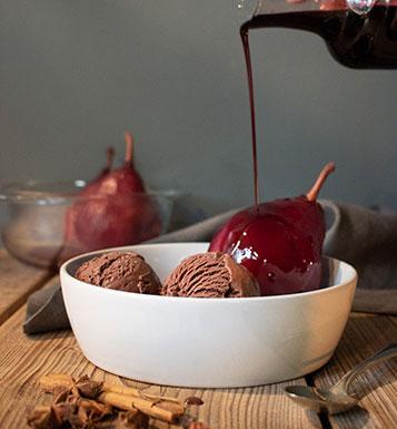 Serviervorschlag von fertigem Eis in Schale mit roter Fruchtsoße