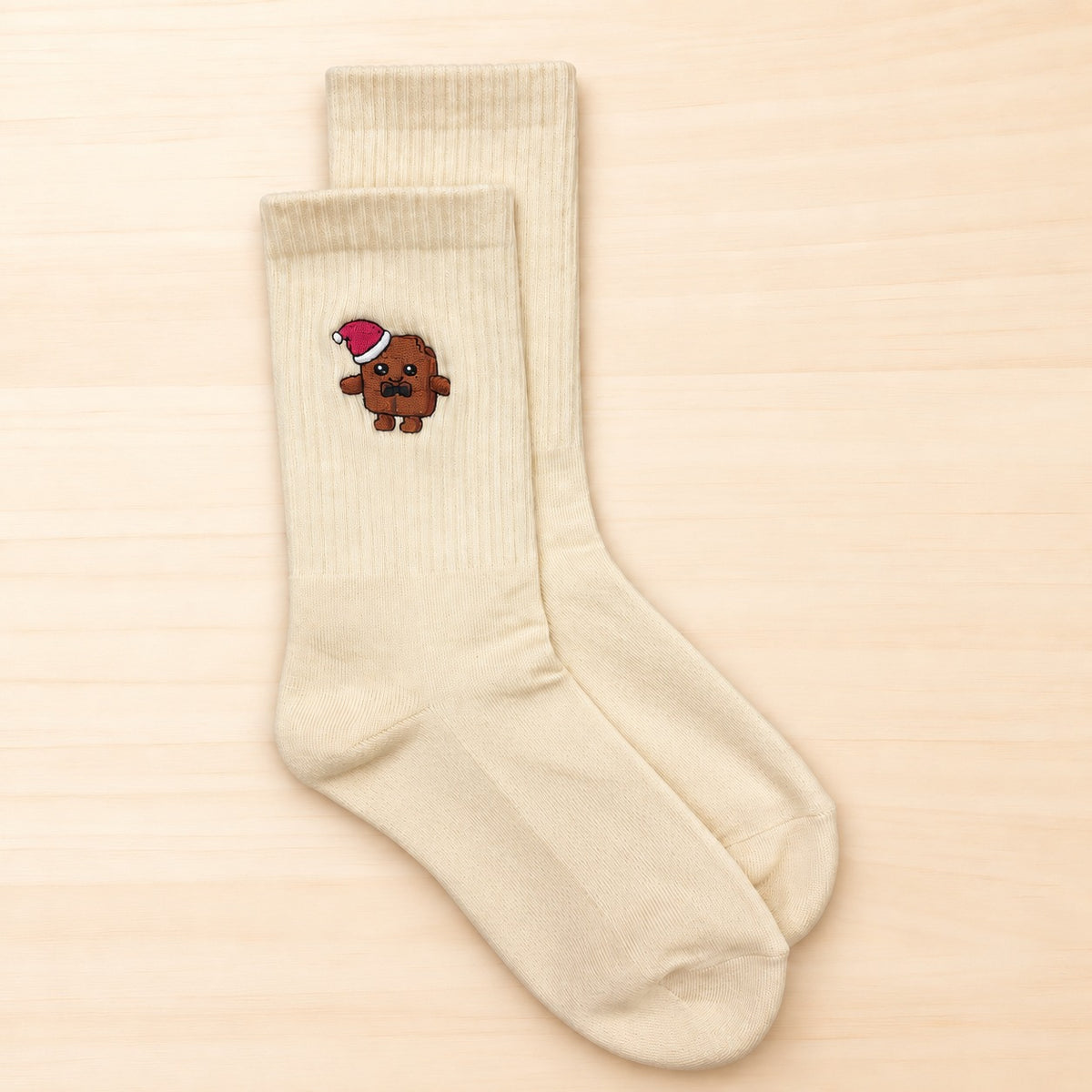 Cremefarbene Baumwoll-Tennissocken mit gesticktem Chocolino-Motiv und roter Weihnachtsmütze.
