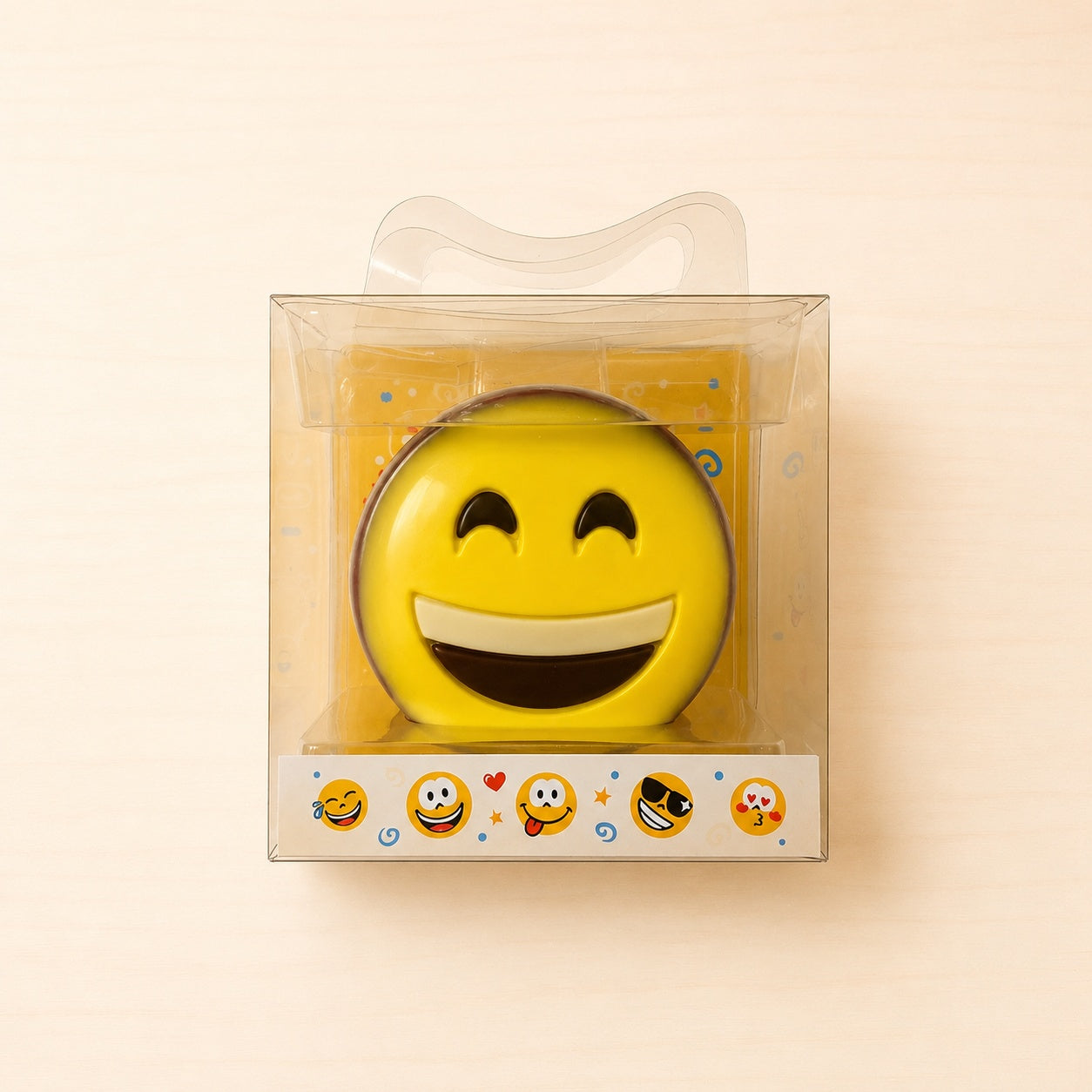 Gelbe Smiley-Schokoladenfigur aus Edelvollmilchschokolade in transparenter Geschenkverpackung.