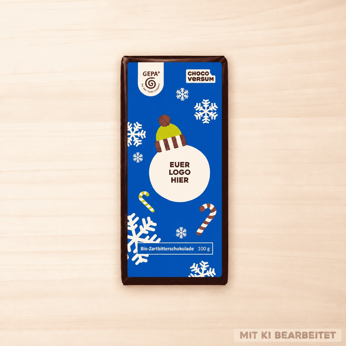 GEPA Bio-Zartbitterschokolade mit blauer winterlicher Banderole, Schneeflocken, Mütze und Platzhalter für ein individuelles Logo.