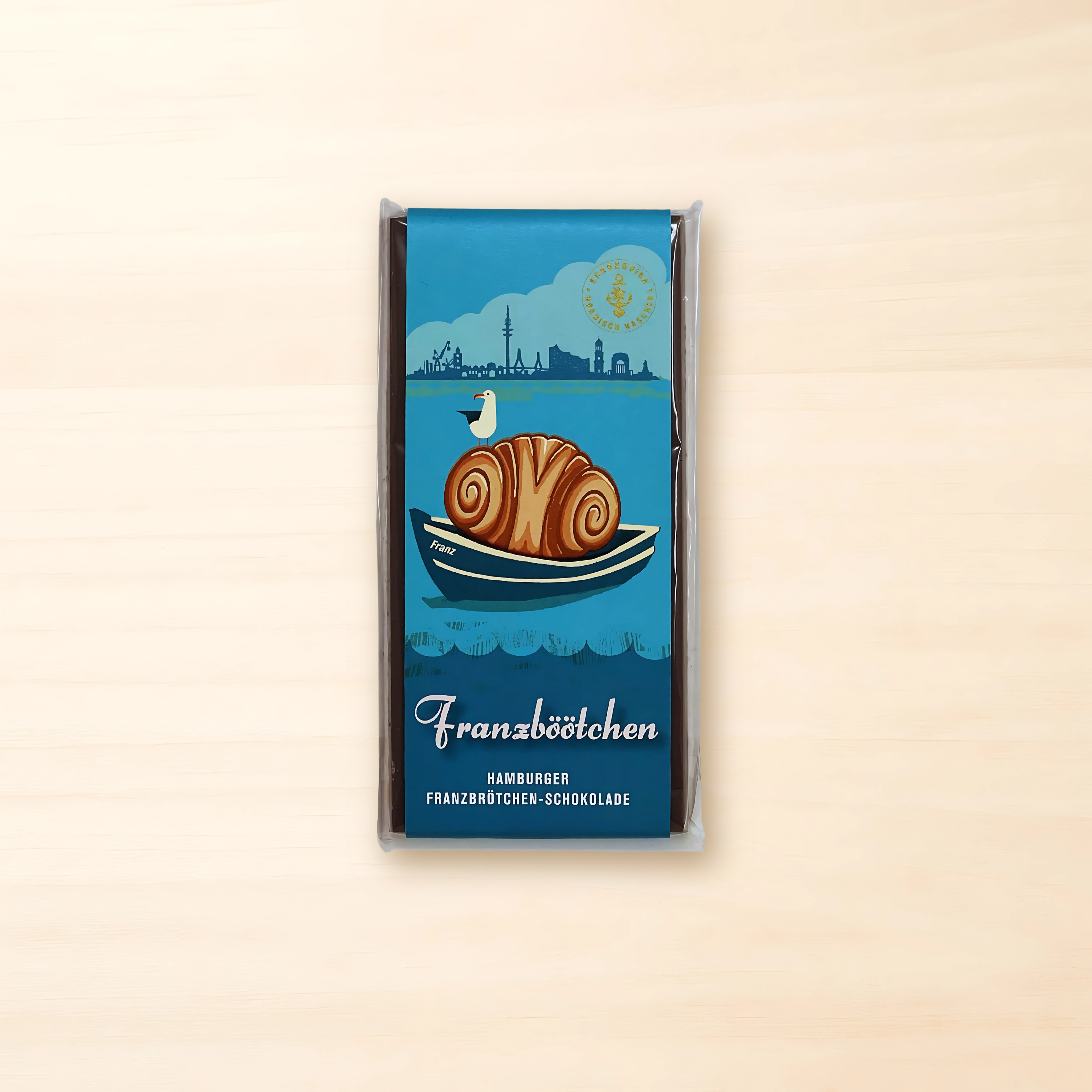 Tafel „Franzböötchen“-Vollmilchschokolade mit blauem Hamburger Design und Illustration eines Franzbrötchens im Boot.