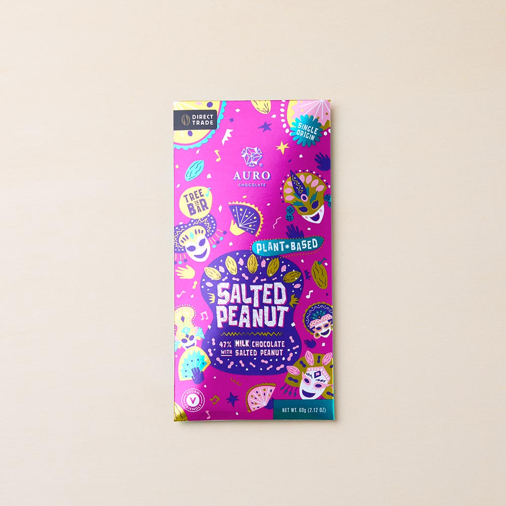 Verpackung der Auro Schokolade „Salted Peanut“ in leuchtendem Pink mit bunten Masken, Früchten und „Plant-Based“-Hinweis, 60 g Tafel mit gesalzenen Erdnüssen.