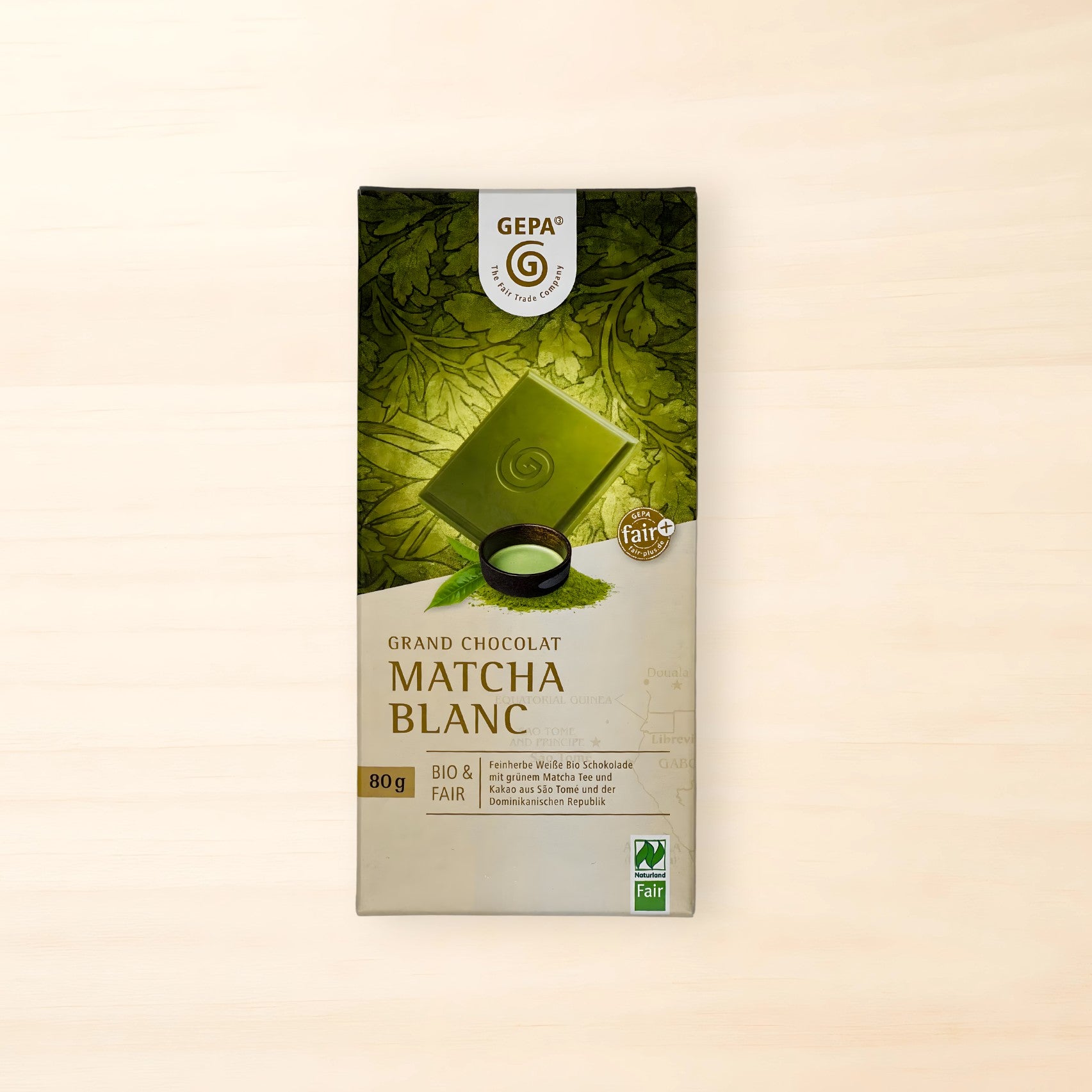 Verpackung der GEPA Grand Chocolat Matcha Blanc (80 g). Die Verpackung zeigt eine grüne Schokoladentafel vor einem Blättermotiv sowie Bio-, Fairtrade- und Naturland-Fair-Siegel.