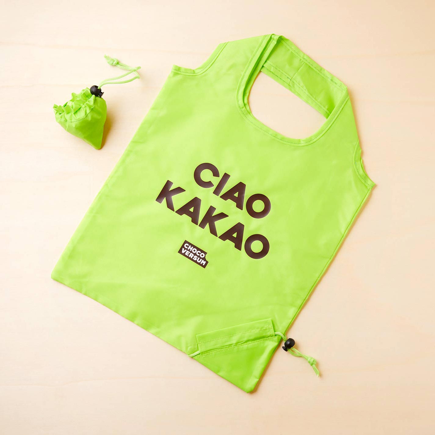 grüner Einkaufsbeutel (zusammenfaltbar) aus Kunststoff mit "Ciao Kakao" Aufdruck in braun und Chocoversum Logo