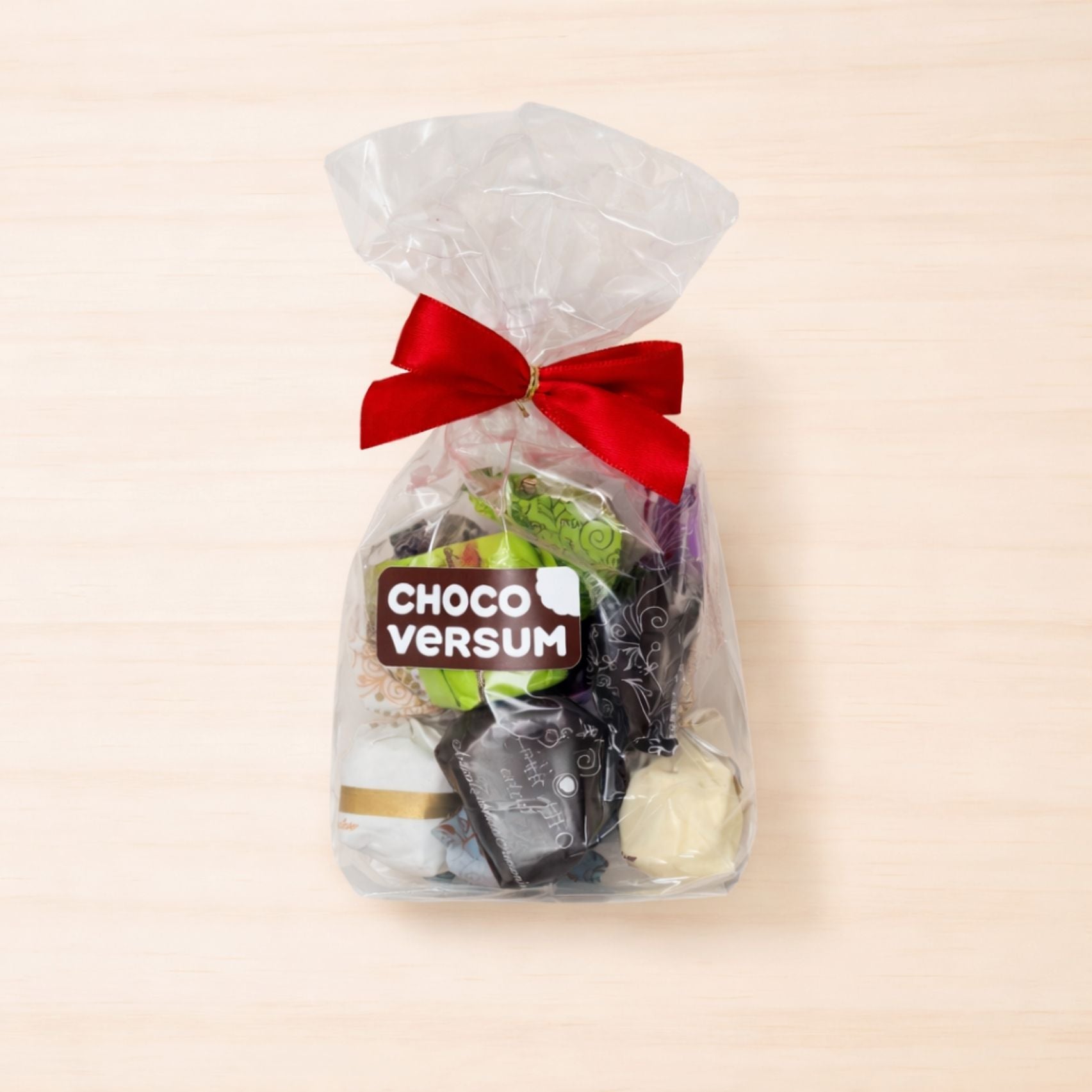 Transparenter Geschenkbeutel mit roter Schleife, gefüllt mit sechs verschiedenen einzeln verpackten italienischen Tartufi-Trüffelpralinen von Antica Torroneria Piemontese.