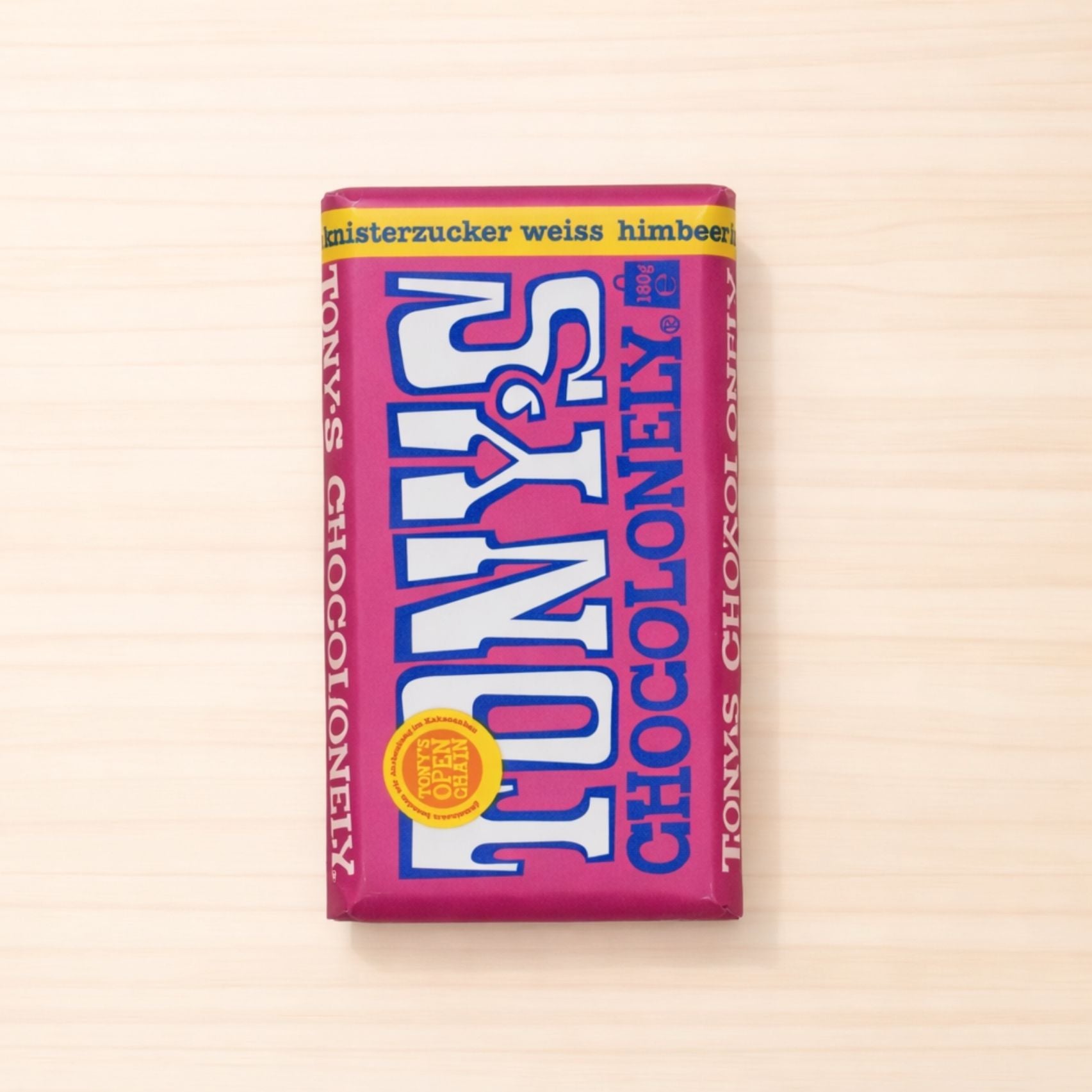 Verpackte Tafel Tony’s Chocolonely weiße Schokolade mit Himbeere und Knisterzucker in pinkem Design